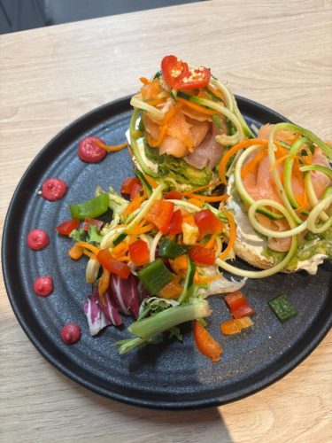 Smashed avocado and salmon on muffin